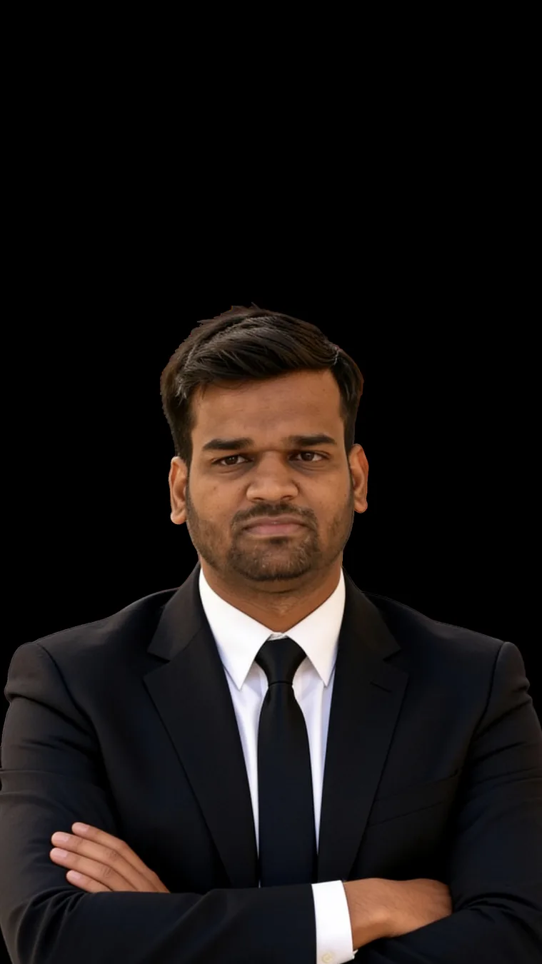 Anuj Kumar in black suit and tie, arms crossed, black background